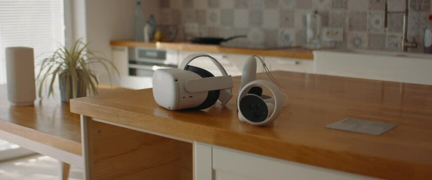 DOLLY IN shot of virtual reality VR headset lying on a table in modern house. Shot with 2x anamorphic lens