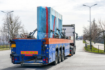 Naklejka premium Transportation of reinforced concrete prefabricated wall panels for house construction by truck