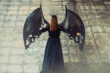 girl in a dress with black bat wings. halloween concept.