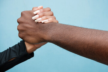 Man and woman shaking hands. Close up and blue background.