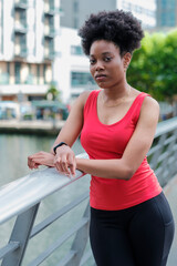Fototapeta na wymiar Portrait of sport fit black woman looking at camera on a bridge.