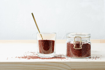 Red quinoa grains in a glass jar.