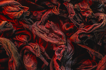 Obraz premium Dry black tea leaves close up. Macro background of tea production on a red light