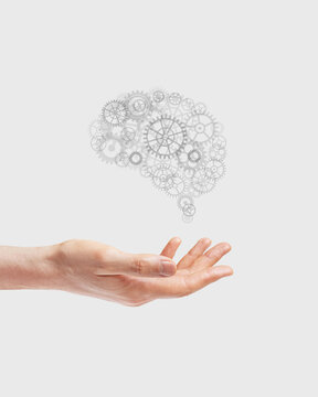 Drawing of a brain from gears in a hand. Concept idea, brain work, development.