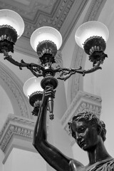 detail of a statue of a woman holding a lamp