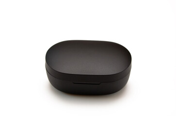 closed small plastic black box on a white background, a case for wireless headphones