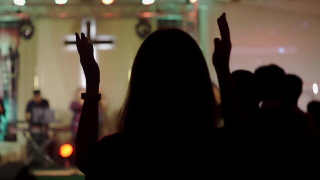 woman applauding Praise Sing Worship God among many people with faith, and hope, at a Christian concert, the church