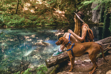 Fototapeta na wymiar Woman Hiking in Mountain Forest with Dog