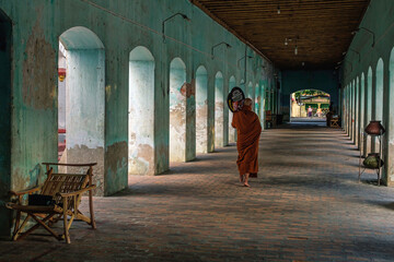 Myanmar, Mandalay, un moine sous les arcades quitte le temple.