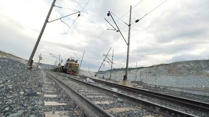 Moving of diesel locomotive and railway cars filled with ore. Quarry for limestone mining.