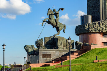 Statue of Saint George killing the serpent at foot of Victory obelisk on Poklonnaya mountain,...
