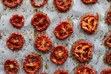 Close-up of Freshly Dried Tomatoes with Herbs on Parchment Paper Straight From the Oven