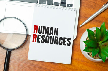 human resources . text on white paper and laptop on wooden background