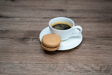 cup of coffee espresso in white cup and macaroons on wooden background