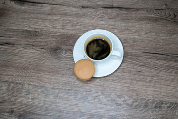 cup of coffee espresso in white cup and macaroons on wooden background