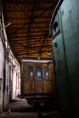 Fototapeta na wymiar Old passenger carriages standing in the building of the historic locomotive shed. The shot was taken in natural lighting conditions