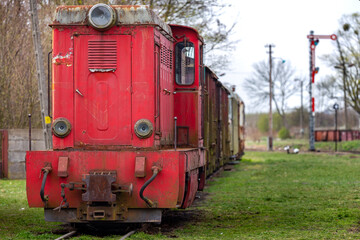 An old, narrow track diesel locomotive standing at the museum's train station. Picture taken on a cloudy day, soft natural light.