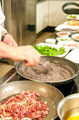 Chef preparing Tutu Beans with Shredded Sun Beef with Onion