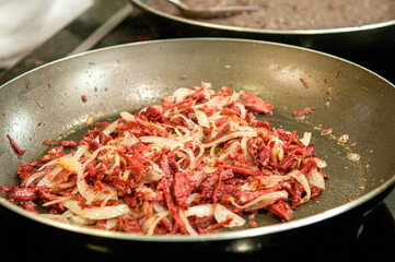 Chef preparing Tutu Beans with Shredded Sun Beef with Onion
