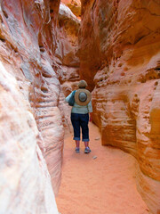 Slot Canyon Hike - A woman walking through a sandstone slot canyon in the Valley of Fire State Park, Nevada