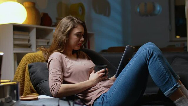 woman using digital tablet at home. relaxing on sofa at home	