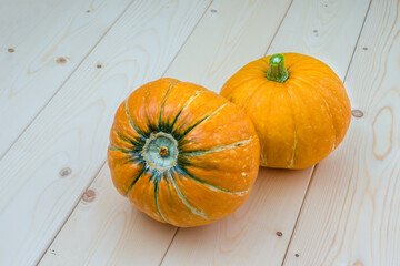 two pumpkins round on a wooden table, top view