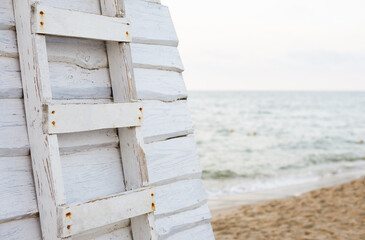 wooden ladder to the tower for lifeguards on the beach against the background of the sky and the sea