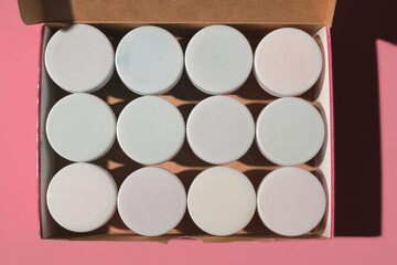 paints with white caps in an open box on a colored background close-up