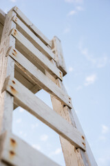 wooden ladder to the tower for lifeguards on the beach against the background of the sky and the sea