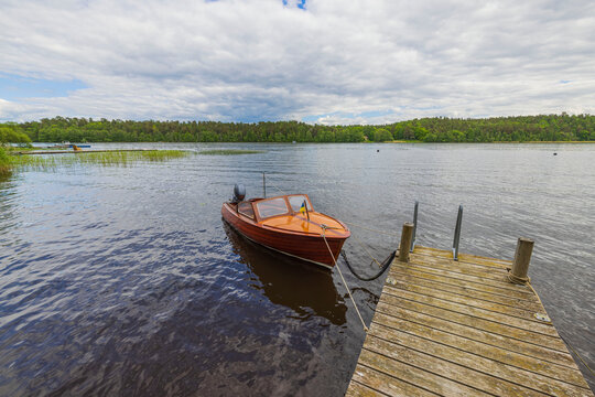 Beautiful view of lake with motor boat parked in shore on water background. Sweden.