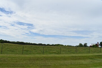 Fototapeta premium Farm Field Under a Blue Cloudy Sky