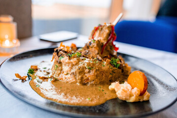 Close-Up of tasty gourmet dinner served in plate. Tempting food displayed on dining table at restaurant. Delicious healthy meal at luxurious resort.