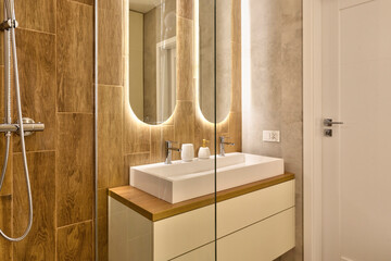Interior of bathroom with ceramic washbasin with faucet, wooden tiles on the wall and modern...