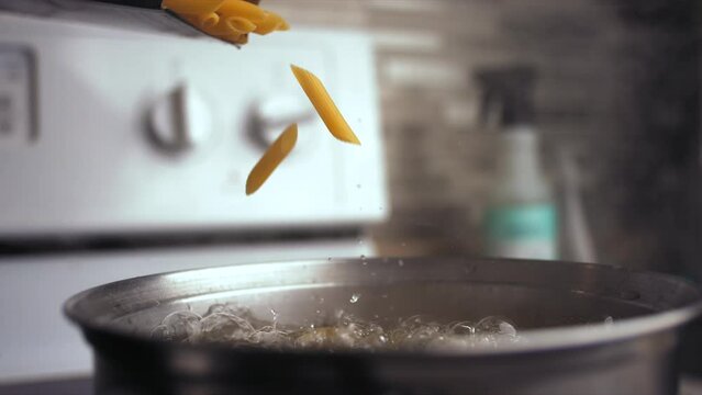 Super slow motion of pasta falling into a pot with boiling water. Filmed on a high-speed cinema camera, 1000 fps