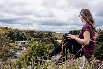Fototapeta na wymiar adventurous woman looking at waterfall view