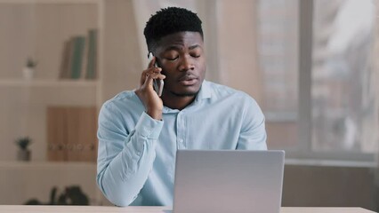 African american man businessman freelancer worker talk chatter on mobile cellphone with client make business call discussion listen news explain information looks at laptop screen use gadget service