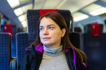 Portrait of European woman sitting on her seat while traveling by train.