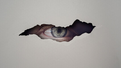privacy concept  with eye peeking through hole 