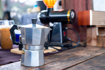 Aluminium moka pot on old wooden table, street food, vintage