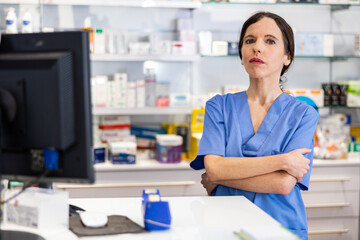 Portrait of caucasian woman druggist standing at counter in pharmacy.