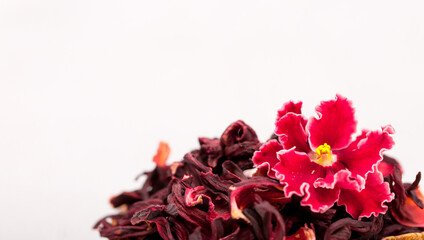 Flower tea karkade. Delicious herbal tropical drink on a bright table. A cup of pink tea from dry...