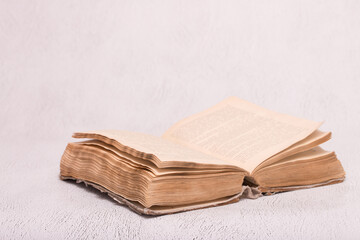 Antique open book on a light table background. Education and science. Knowledge of old Tielerature. Copy space with space for text.