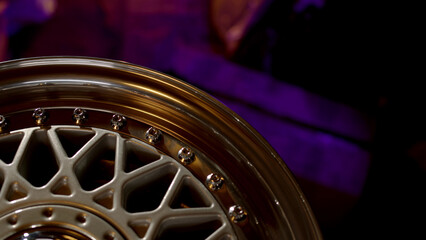 Top down close up view of part of classic three-piece or two-piece wheel rim under yellow light...