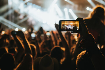 Fototapeta na wymiar Silhouette of a woman using smartphone on a concert