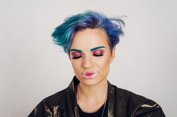 Portrait of a woman with colorful vivid makeup on a white studio background