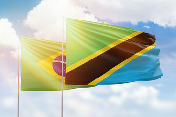 Sunny blue sky and flags of tanzania and brazil