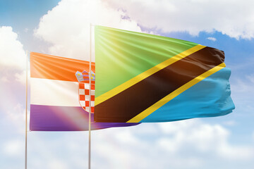 Sunny blue sky and flags of tanzania and croatia