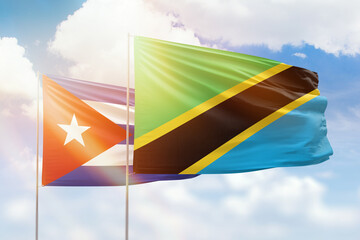 Sunny blue sky and flags of tanzania and cuba