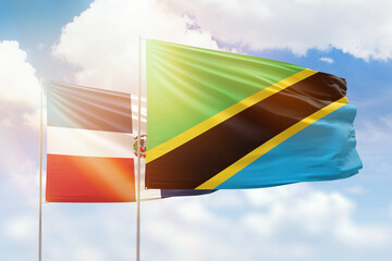 Sunny blue sky and flags of tanzania and dominican republic