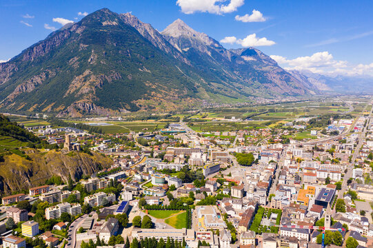 View from drone of houses of commune Martigny and river Drance in mountain valley, Switzerland